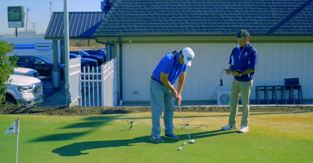 Bo coaching a student on the putting green